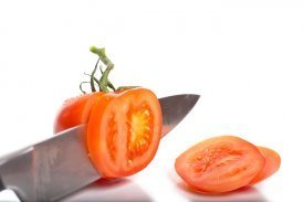 Un cuchillo cortando un tomate