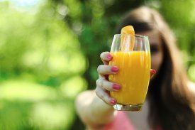 Una chica con un zumo de naranja